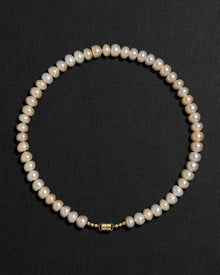 Blush pearl necklace with a 18K gold  clasp on a black background