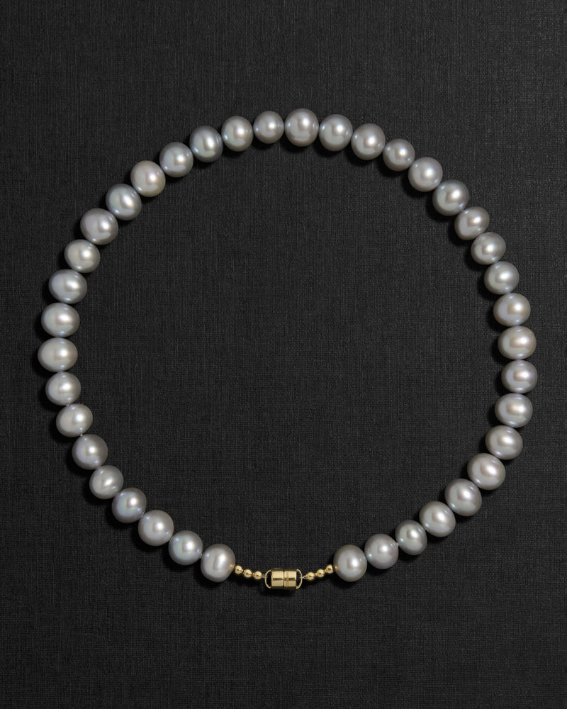 Grey pearl necklace with a 18K gold clasp on a black background