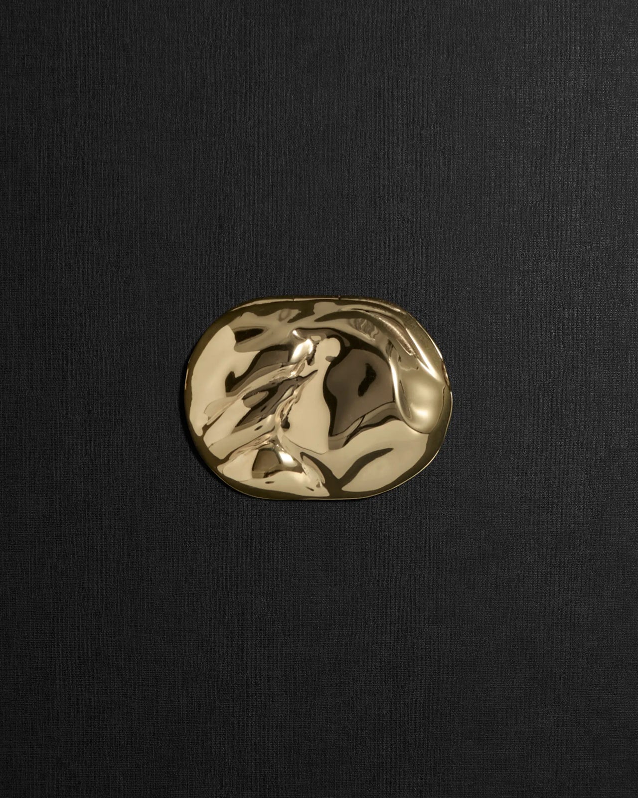 Desert-shaped 18K gold pendant on a black background