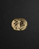 Desert-shaped 18K gold pendant on a black background