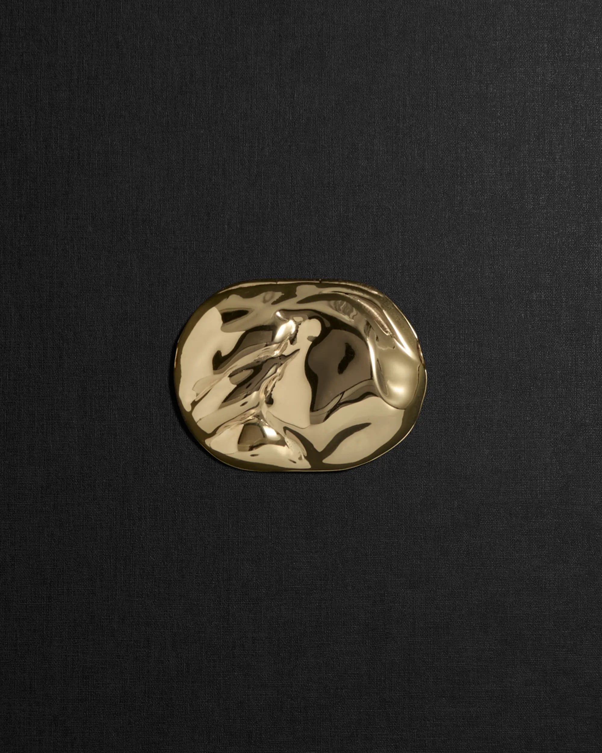 Desert-shaped 18K gold pendant on a black background