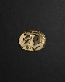 Desert-shaped 18K gold pendant on a black background