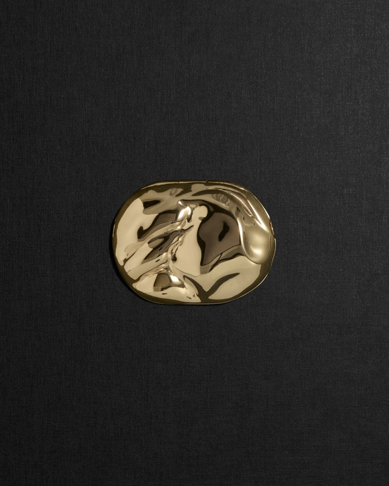 Desert-shaped 18K gold pendant on a black background