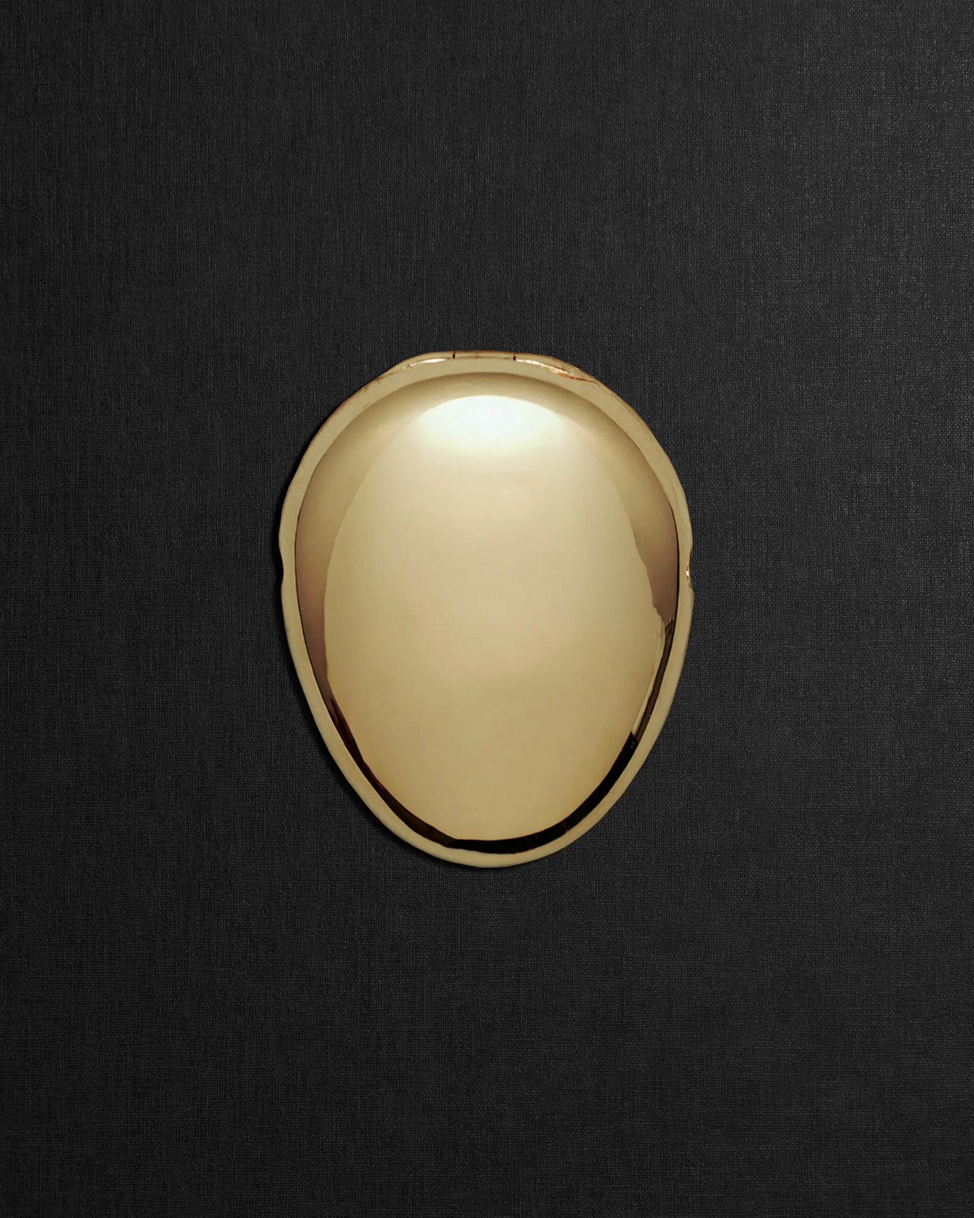 Pebble-shaped 18K gold pendant on a black background