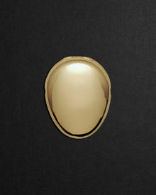 Pebble-shaped 18K gold pendant on a black background