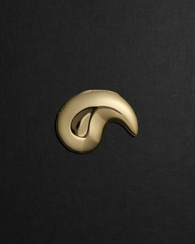 Spiral-shaped 18K gold pendant on a black background