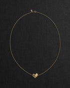 18K gold rollo chain necklace with a heart-shaped pendant on a black background