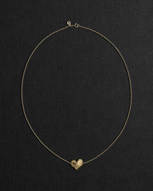 18K gold rollo chain necklace with a heart-shaped pendant on a black background