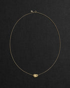 18K gold rollo chain necklace with a pomegranate-shaped pendant on a black background