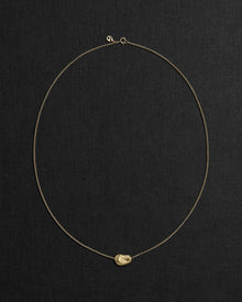 18K gold rollo chain necklace with a pomegranate-shaped pendant on a black background
