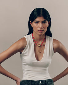Model wearing 18K gold red cord necklace  with 18K gold pomegranate-shaped pendant and mini 18K gold pomegranate-shaped pendants