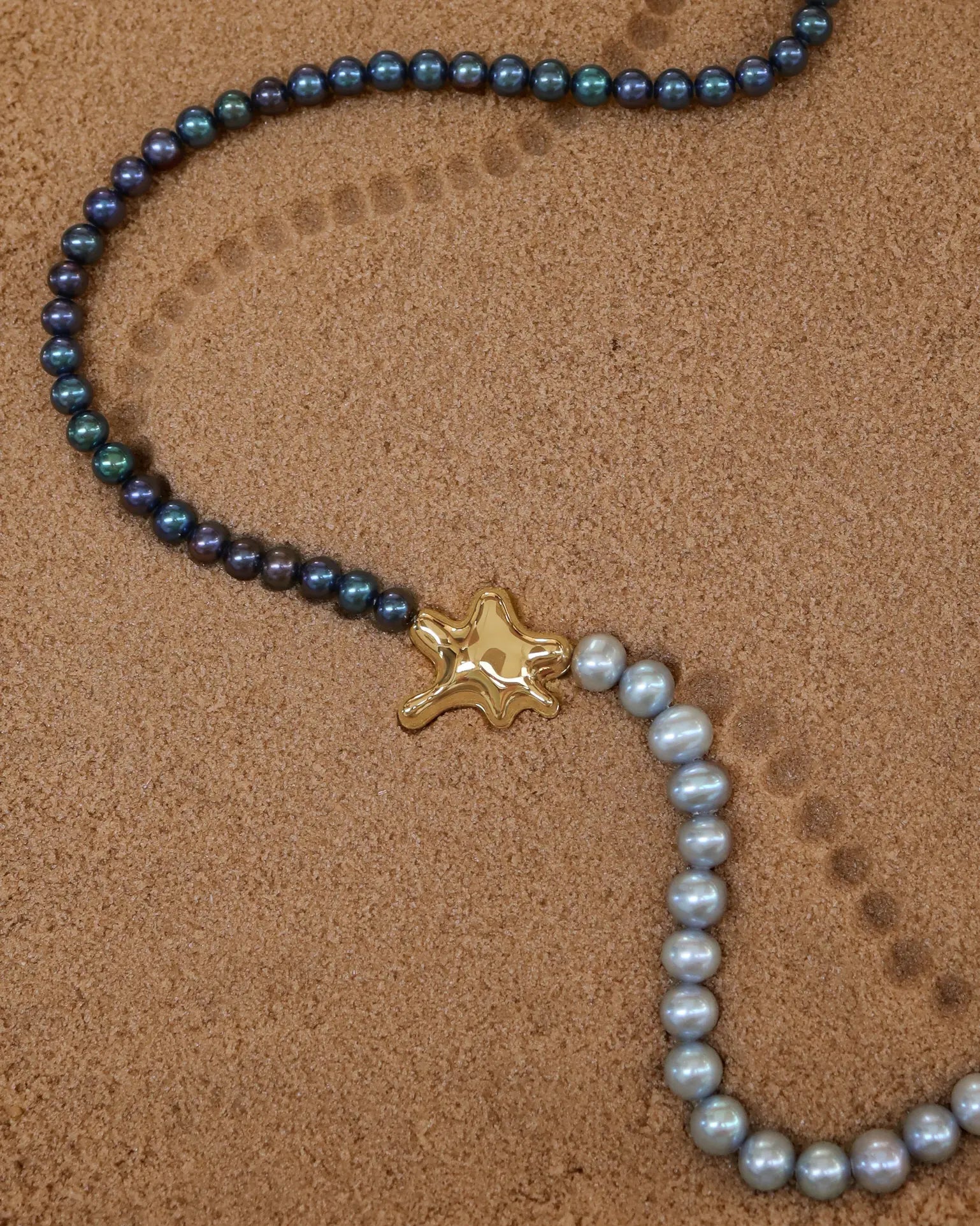 18K Gold Hero Water pendant, 18K Gold Freshwater pearl in Grey, 18K Gold Freshwater pearl in Midnight on a sand
